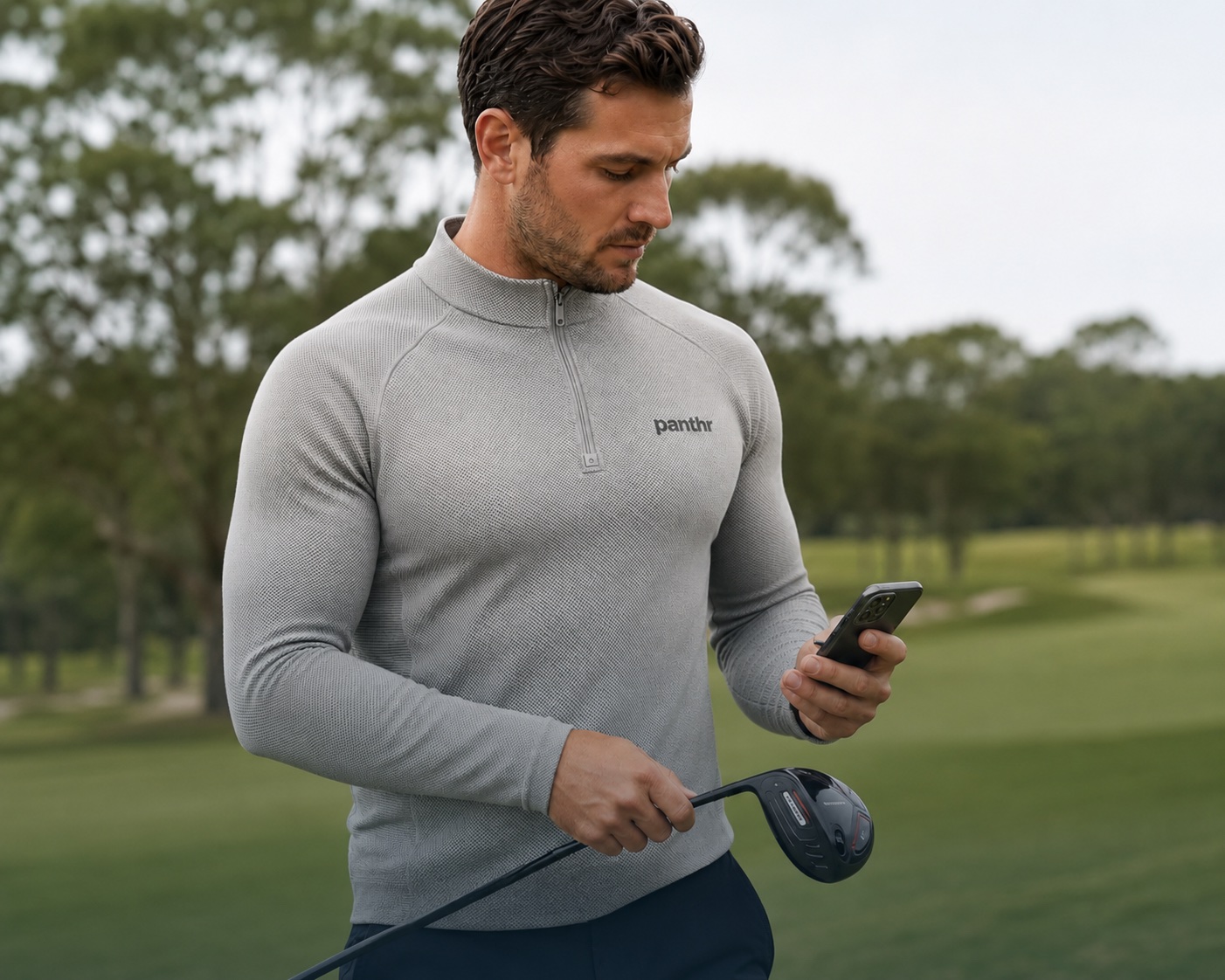 Golfer wearing a panthr shirt and reviewing information on his phone